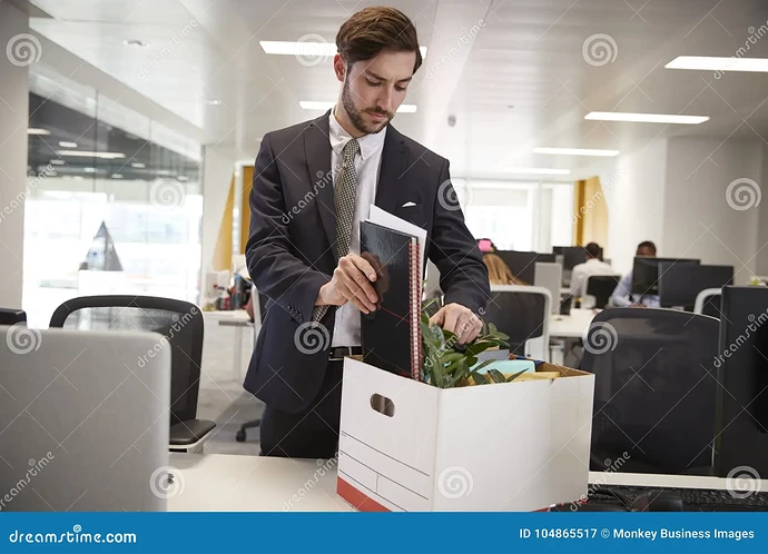 fired-male-employee-packing-box-belongings-office-104865517